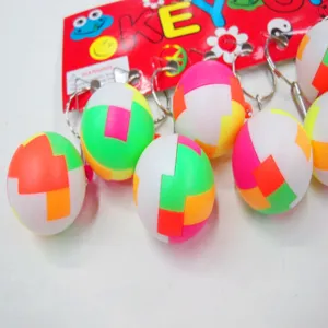 Close-up of colorful 2.5cm puzzle ball keychains attached to a red display card