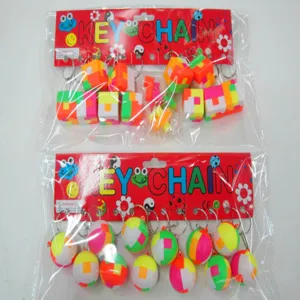 Close-up of multicolored 2.5cm magic cube and puzzle ball keychains in retail packaging