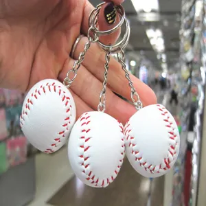 Detailopname van witte honkbal sleutelhangers met rode stiksels en zilveren ringen