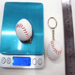 Meetdetail van witte honkbal sleutelhanger met gewicht van 14 gram op blauwe schaal