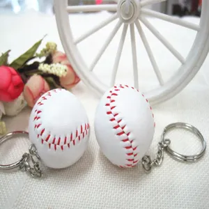 Detailopname van witte honkbal sleutelhangers met rode stiksels en zilveren ringen