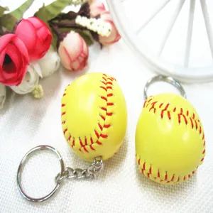 Gedetailleerd overzicht van gele softbal sleutelhanger met rode stiksels op wit oppervlak