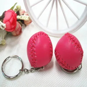 Detailweergave van een roze honkbal sleutelhanger met rode stiksels en zilveren ring.