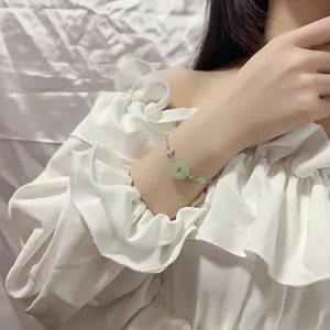 Vue détaillée d'un bracelet en argent de style chinois avec jade vert et breloque