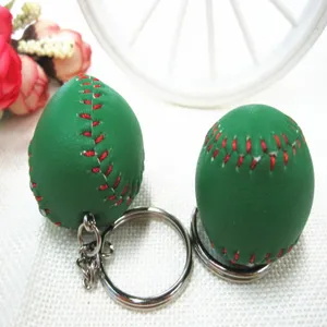 Close-up van groene honkbal sleutelhangers met rode stiksels en zilveren ringen.