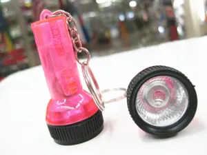 Detailansicht eines rosa Mini-LED-Taschenlampen-Anhängers mit Leuchtkopf und Gehäuse.