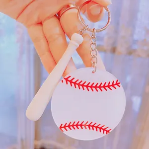 Detailed view of white acrylic baseball keychain with red stitching and mini bat.