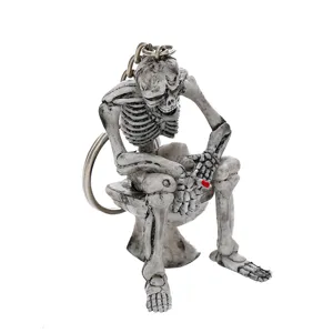 Macro detail of a creative skeleton figurine sitting on a toilet keychain Halloween gift