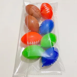 Close-up van acht kleurrijke mini-football-bedeltjes in een transparant zakje.