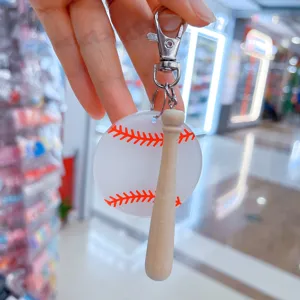 Detail view of acrylic baseball keychain with printed red stitches and wooden bat charm