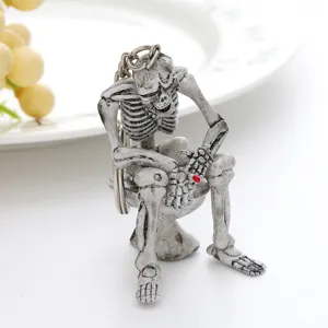 Detailed view of a quirky skeleton figurine sitting on a toilet bowl keychain for Halloween