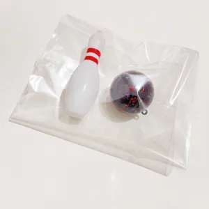 Detail view of mini bowling pin and ball accessory inside clear plastic packaging.