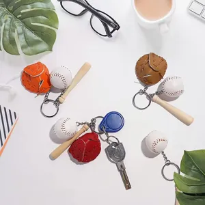Detail view of colorful baseball glove, bat and ball keychain accessories on white desk
