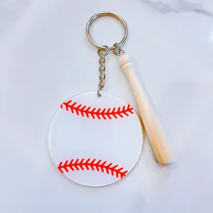 Detailed view of acrylic baseball keychain with miniature wooden bat and red stitching.
