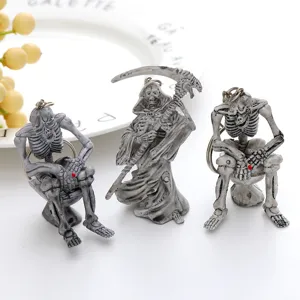 Set of three unique Halloween skeleton keychains including two sitting on toilets and one reaper