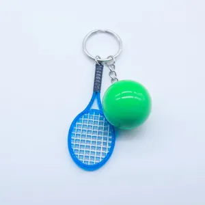 Detailed macro view of a mini blue tennis racket and green ball sports keychain pendant