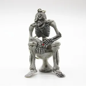 Macro view of a funny resin skeleton sitting on a toilet keychain Halloween gift