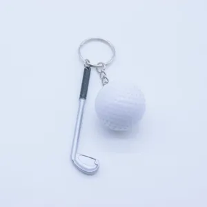 Close-up detail of creative miniature golf ball and club silver keychain pendant