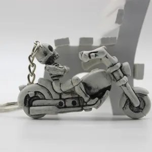 Side view detail of a gothic skeleton figurine riding a motorcycle pendant keychain