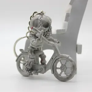 Detailed side view of a skeleton figure riding a bicycle moped keychain accessory