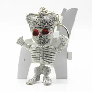 Close-up of a white crowned skeleton keychain featuring red eyes for Halloween decor