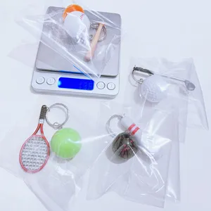 Close-up of mini sports keychains set being weighed on a digital scale in plastic bags
