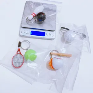 Macro detail of mini sports keychains on digital scale weighing 23 grams in plastic bags