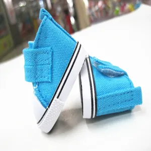 Nahaufnahme von kleinen 5 cm blauen Segeltuch-Sneakern mit Klettverschluss für BJD Puppen.