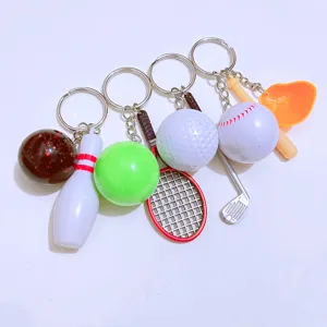 Close-up of mini sports keychains featuring bowling, tennis, golf, and baseball designs.