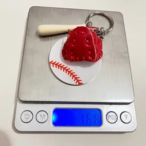 Acrylic baseball keychain set with bat and glove weighing 16.8g on digital scale