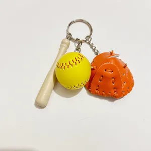 Detail view of mini baseball keychain with bat, yellow softball, and orange glove.