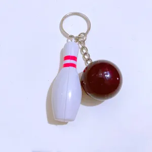 Detailed close-up of a mini bowling keychain featuring a white pin and dark red ball pendant.