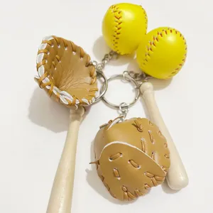 Close-up detail of a mini baseball glove, bat, and yellow ball keychain.