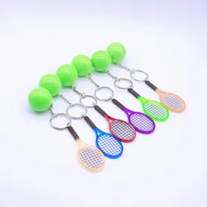 Miniature tennis racket and ball keychains in assorted vibrant colors on white background
