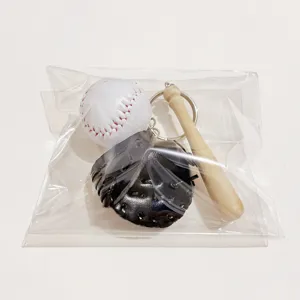 Detail view of a sports-themed baseball keychain set with ball, bat, and glove in packaging