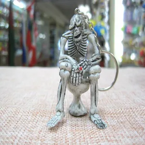 Macro detail of unique skeleton sitting on toilet keychain for Halloween gift