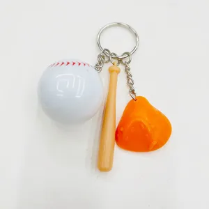 Detailed close-up of mini baseball keychain with bat and glove charms on white background
