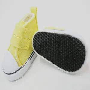 Nahaufnahme von 5 cm gelben Puppen-Stoffschuhen mit Klettverschluss und rutschfester Sohle