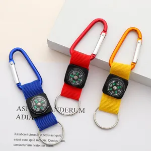 Detail view of three colorful aluminum carabiner compass keychains in blue, red, and yellow.