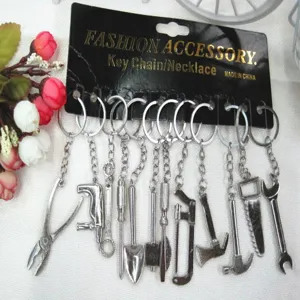 Collection of mini silver metal hardware tool keychains displayed on black card
