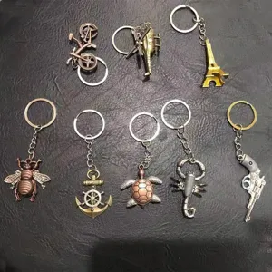 Collection of assorted vintage metal keychains featuring bicycle, anchor, and animal shapes
