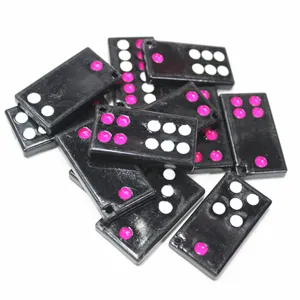 Vue macro de breloques domino en résine noire avec des points roses et blancs éclatants