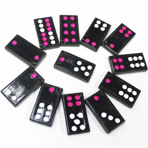 Vue détaillée de tuiles de Pai Gow miniatures noires avec des points roses et blancs