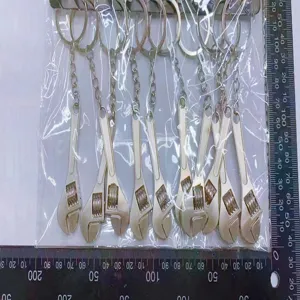 Close-up detail of mini adjustable wrench keychains shown with measurement ruler