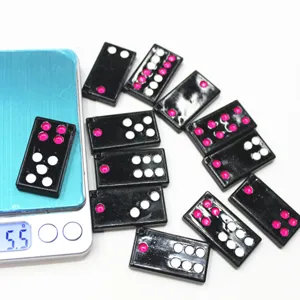 Détail de mini dominos Pai Gow noirs sur une balance électronique affichant un poids de 5,5g.
