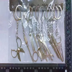 Detailed close-up view of mini metal tool keychains set with ruler for size reference