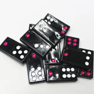 Vue détaillée des pendentifs noirs en forme de tuiles Pai Gow avec points roses et blancs