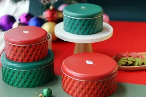 Gros plan détaillé de boîtes de Noël en métal à carreaux rouges et verts avec Père Noël