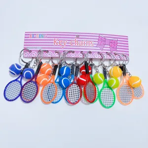 Detailed view of various colorful mini tennis racket and ball keychains on display card