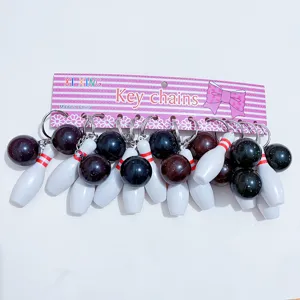 Miniature bowling pin and ball keychains sets shown on pink retail card packaging